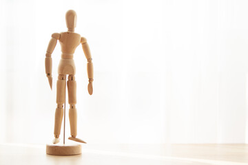 Wooden anatomy figure on the wooden table close to window with copy space.