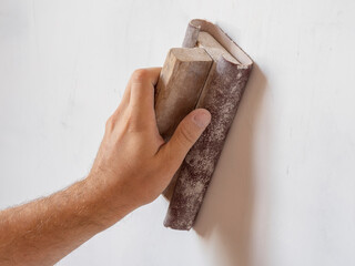 use sandpaper to sand the wall surface. Surface leveling, work inside the house.