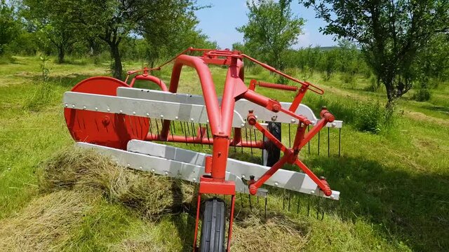 Hay Tedder Machine At Work Making Hay At The Field On A Sunny Day - close up