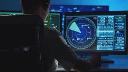 Workplace of the professional air traffic controller in the control tower. Caucasian aircraft control officer works using radar, computer navigation and digital maps.