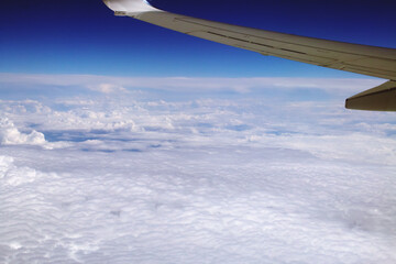 Naklejka na ściany i meble Un bonito mar de nubes vistos desde arriba. Fotografía hecha del cielo desde la ventanilla de un avión comercial.
