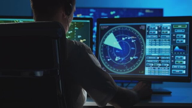 Workplace of the professional air traffic controller in the control tower. Caucasian aircraft control officer works using radar, computer navigation and digital maps.