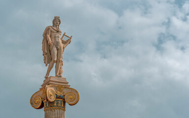 Apollo, the ancient Greek god of arts under cloudy sky, Athens, Greece, space for your text