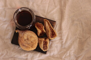 dried figs and fig juice on wooden dish with brown background. space for text, backlight