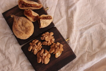 Top view dried fig and walnut are healthy food, healthy sugar for health life. Brown food background closeup. Space for text.