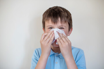 cheerful child wipes nose white handkerchief. Nose hygiene. Teaching children how to protect...