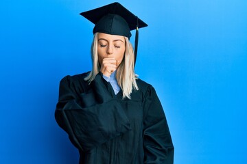 Beautiful blonde woman wearing graduation cap and ceremony robe feeling unwell and coughing as symptom for cold or bronchitis. health care concept.