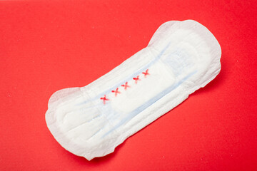 Feminine pad on a red background. Hygiene product for menstruation.