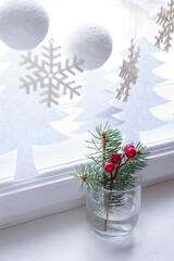 Christmas decoration windowsill. Fir tree branch in glass.