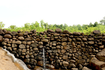 view of water falling from small stone wall at bilpudi (Gujarat) (India)