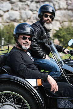 two men on sidecar bike looking at camera
