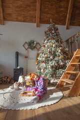 happy little girl playing near christmas tree at home, winter holidays, real people