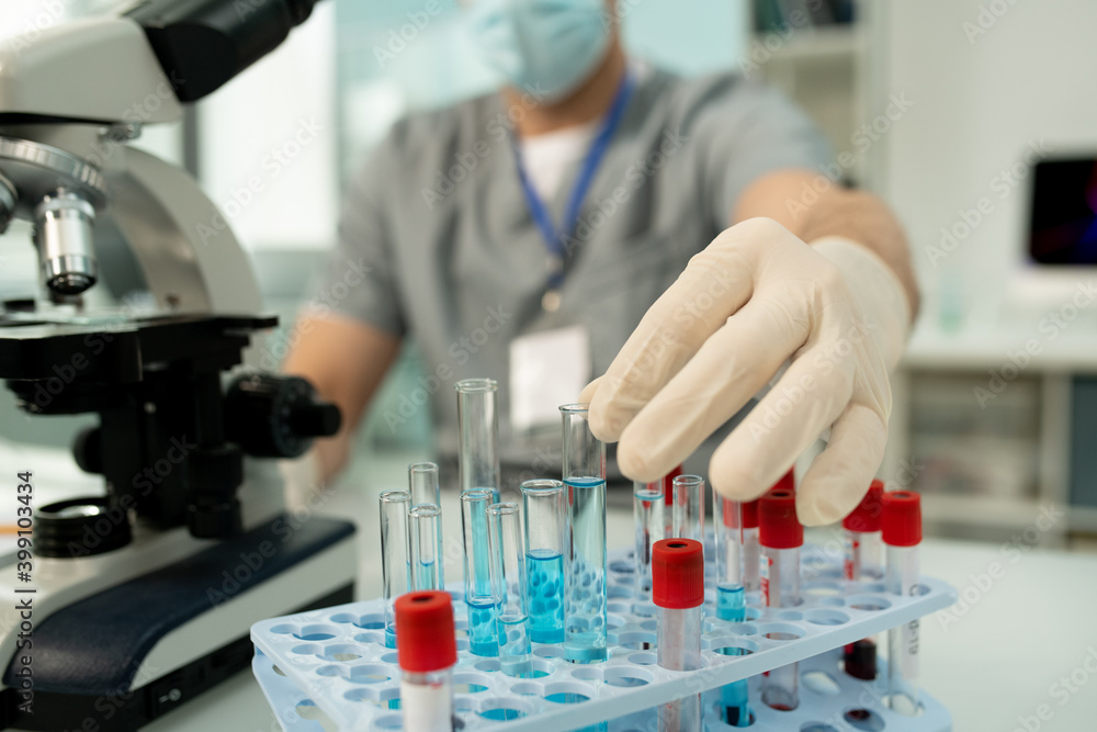 Poster gloved hand of worker of medical laboratory taking flask with new vaccine