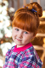 happy little girl playing near christmas tree at home, winter holidays, real people
