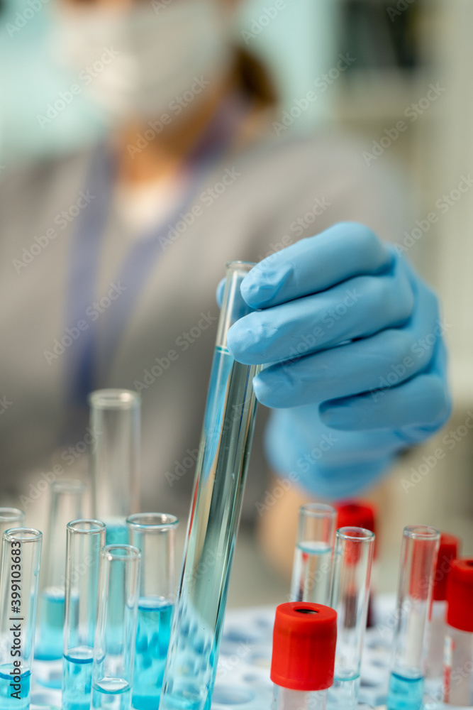 Poster Gloved hand of clinician taking flask with sample of vaccine before testing it