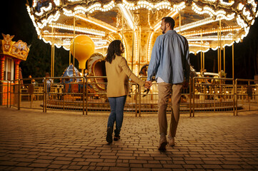 Love couple at the carousel, night amusement park