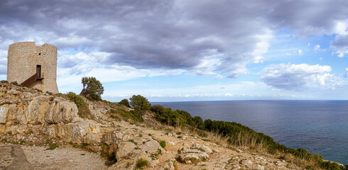 Fototapeta na wymiar Panorámica de paisaje natural de Cala Montgó y su torre, en un día nuboso, en l'Estartit, Costa Brava, Girona, Febrero de 2018