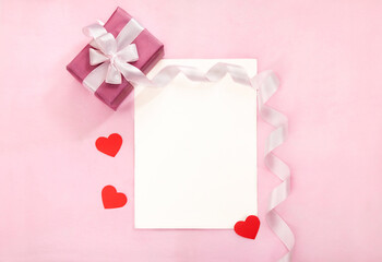 Valentines day greeting card with pink gift box, white bow, long curved ribbon and paper red...