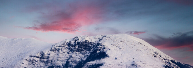 Stunning panoramic view of a snow capped mountain range during a dramatic sunset. Campocatino, Frosinone, Italy.