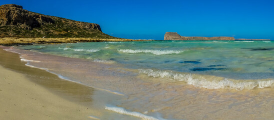 Obraz premium A view of Balos Beach and the azure lagoons out towards Gramvousa island, Crete on a bright sunny day