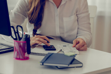 Close up of woman in formal wear sitting at her work place in front of computer