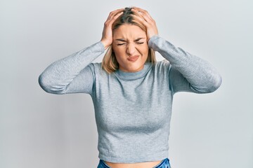 Young caucasian woman wearing casual clothes suffering from headache desperate and stressed because pain and migraine. hands on head.