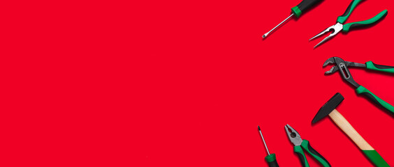 A set of quality green building tools to repair a car or a house on a red background. Do it yourself instruments. Banner for advertising construction shop with copy space. Business card