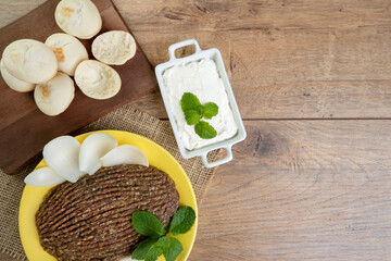 raw quibe with sliced onion, dried curd, pita bread and mint leaves