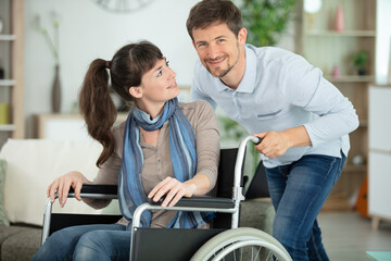 handicapped young pretty woman in wheelchair and her partner