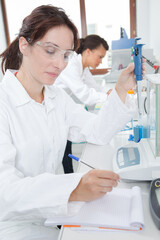 female researcher recording experiment in notebook