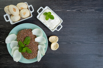 raw quibe with sliced onion, dried curd, pita bread and mint leaves