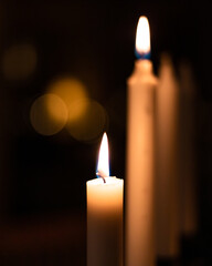 Advent candles burning flames in the dark, beautiful bokeh orbs 