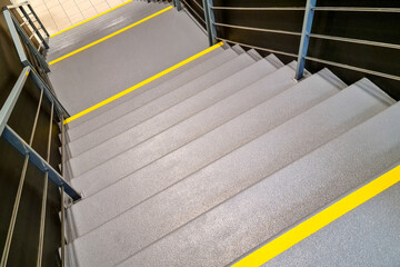 public building stairs with a yellow warning stripe