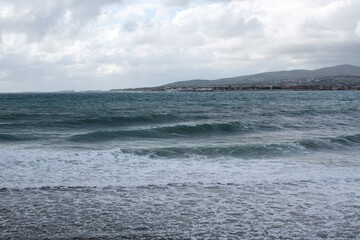 Blue waves on the sea with white foam near the shore