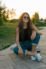 beautiful young woman with skateboard summer portrait