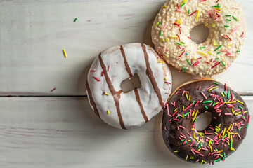 Various fresh-baked donuts on a wooden background