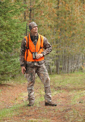 modern deer hunter standing in forest full length