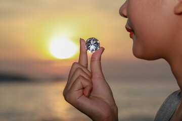 .women pick a diamond into the sun at Patong beach,Phuket.