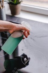 Hands spraying with refillable zero waste spray bottle for the kitchen with water,
soda, soap,...