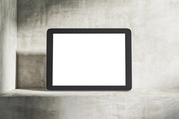 Digital tablet on concrete shelf with blank white screen.