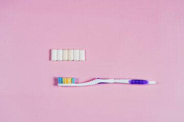 toothbrush and chewing gum on a pink background. High quality photo