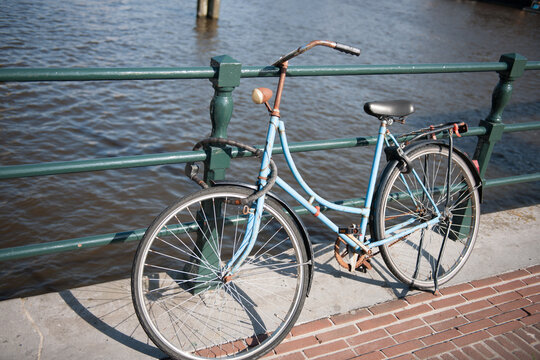 Rusty old bike locked to bridge in Amsterdam stock picture