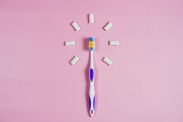 toothbrush and chewing gum on a pink background. High quality photo