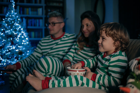 Dad, Mom And Son Are Watching A Movie In A Christmas Night