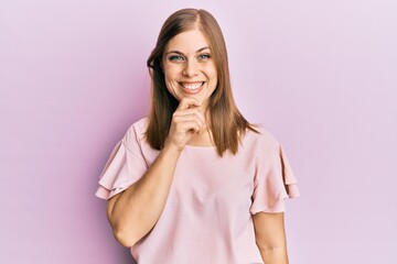 Beautiful caucasian woman wearing casual clothes smiling looking confident at the camera with crossed arms and hand on chin. thinking positive.