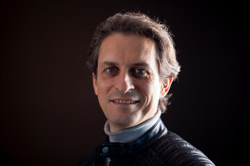 Retrato de hombre de mediana edad sobre fondo oscuro