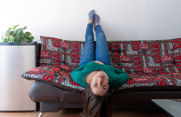 Young woman laying head down on the couch