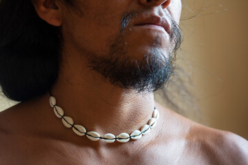 Closeup of native male neck wearing natural white shell choker necklace