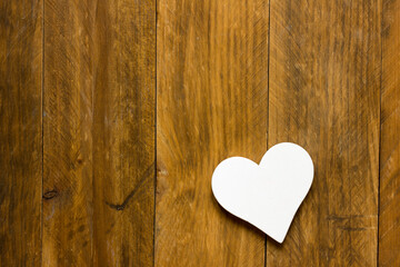 White heart on aged wood background seen from above