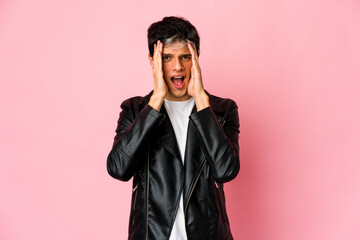 Obraz premium Young skinny hispanic man having fun covering half of face with palm.